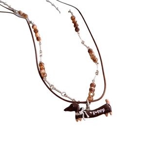 Ethnic wax cord necklace featuring a brown dachshund puppy pendant and beaded accents