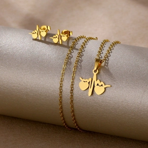 Golden heartbeat and heart jewelry set with necklace and earrings on display stand