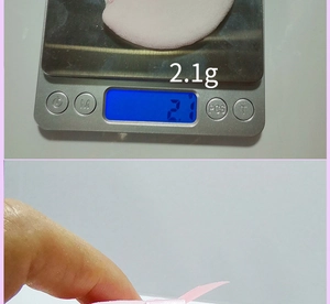 Detailed view of lightweight 2.1g pink triangular powder puff with ribbon handle
