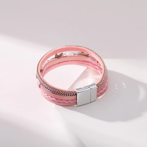 Macro detail of a pink multi-layer braided bracelet with rhinestones and magnetic buckle