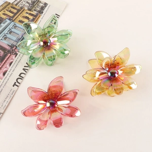 Three elegant electroplated iridescent flower hair claws in green yellow and pink hues