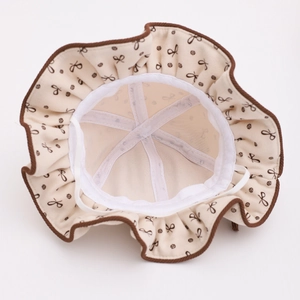 Détail du chapeau bébé avec motif nœud, doublure respirante et cordon de protection