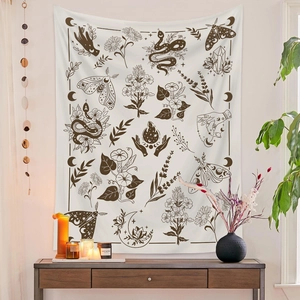 Detail view of white bohemian tapestry with black snake, moth and moon occult patterns
