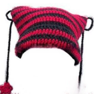 Detail of red and black striped knit cat ear hat with stars and tassel drawstrings