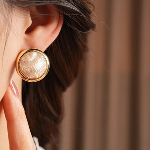 Détail de la boucle d'oreille plaquée or 16K avec texture perle sur l'oreille