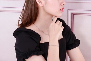 Close-up of model wearing silver oval link chain necklace and matching bracelet set