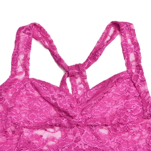 Gros plan sur la dentelle rose et les motifs floraux délicats du haut à licou sexy