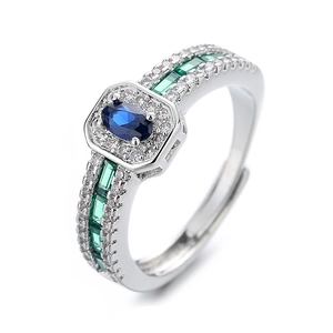 Vintage silver ring with oval blue sapphire and green cubic zirconia in a halo setting