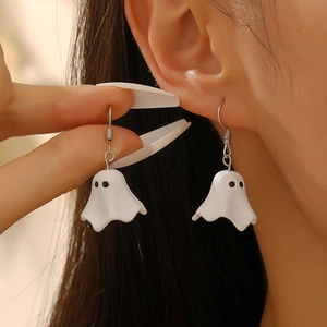 Macro shot of white ghost drop earrings featuring silver hooks and black eye details
