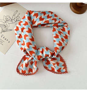 Detail of floral cotton linen scarf with orange crochet lace trim on white background