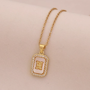 Détail du collier en or 18 carats avec pendentif rectangulaire en nacre et lettre H