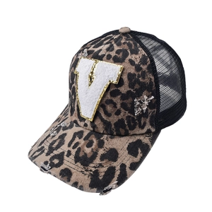 Close-up of leopard print mesh trucker hat with embroidered V patch and distressed brim