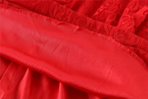 Detail of red floral lace fabric with smooth matching lining and fine stitching
