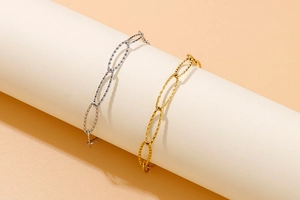 Close-up of sparkling gold and silver stainless steel chain bracelets on a display stand