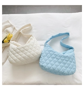 Close-up of white and light blue quilted hobo bags with diamond texture and soft padding
