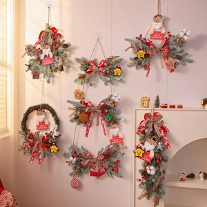 Christmas wreath with red berries, pine needles, and Feliz Navidad signs on a white wall