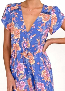 Detail of V-neck printed dress showing blue floral pattern and delicate hollow lace stitching