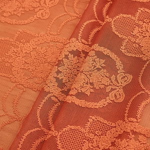 Close-up of terracotta lace tablecloth featuring intricate embossed floral mesh patterns