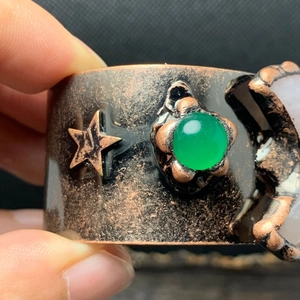 Makro-Detail des Vintage-Bronze-Armreifs mit grünem Aventurin und Mond-Stern-Elementen