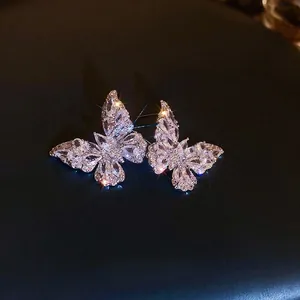 Sparkling zircon butterfly stud earrings in silver finish on a dark background