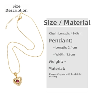 Detail of gold heart pendant with red and white zircons on a delicate bead chain necklace