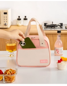 Detail of pink insulated lunch bag front pocket with phone storage and Tasty Food label