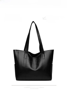 Detail view of The Wing bag in black faux leather with subtle pebble grain texture