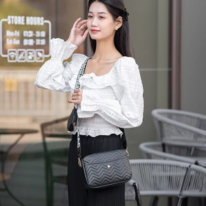 Black V-quilted crossbody camera bag with lettered strap and small coin purse attached
