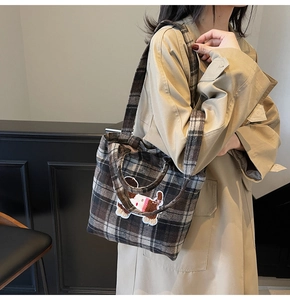 Detailed texture of brown plaid wool tote bag featuring a cute cartoon dog embroidery