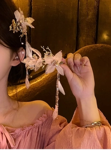 Dettaglio del fermaglio per capelli a farfalla in pizzo rosa con nappe di perle