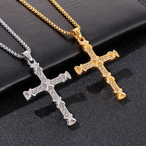 Detail of silver and gold iced-out hip hop cross pendants with box chain on leather