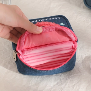 Blue denim portable makeup bag with Love You embroidery being opened by hand