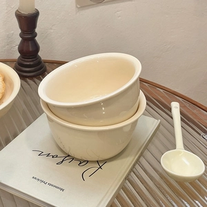 Cream white ceramic bowl set stacked on vintage books with minimalist french aesthetic