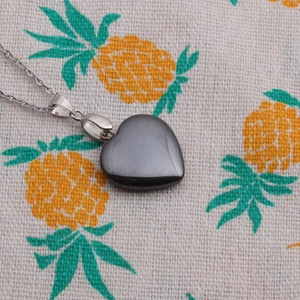 Gros plan d'un pendentif cœur en hématite au lustre métallique gris foncé sur chaîne