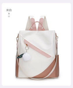 Detail of cream white waterproof backpack with brown contrast and pompom charm