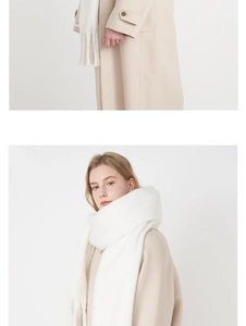 Detail of soft white cashmere-like scarf showing thick plush texture and fringe tassels