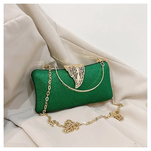 Detail of green glitter evening bag with gold leaf clasp and metal chain strap