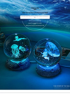 Detailed 3D laser engraved crystal ball with jellyfish and astronaut motifs on LED base