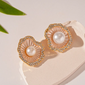Vue macro des boucles d'oreilles perles en forme de coquillage doré avec cristaux