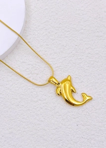 Detailed view of polished golden dolphin pendant on a sleek snake chain necklace