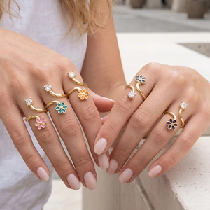 Elegant gold flower rings with colorful enamel and zircon stones on a model's hand
