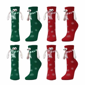 Detailed view of red and green Christmas socks with 3D arms and snowflake knit patterns