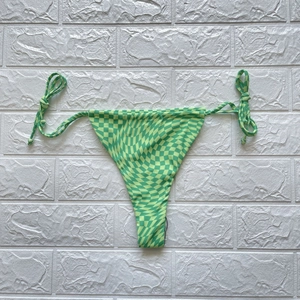 Detail von grünem Bikini-Unterteil mit verzerrtem Schachbrettmuster und seitlichen Bändern