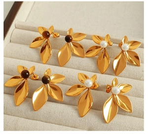 Detail view of gold flower earrings with pearls and gemstones in a jewelry box