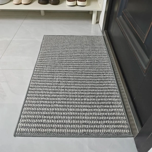 Detail view of gray and white woven door mat with durable fiber texture and gray piping