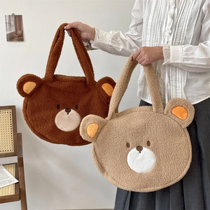 Detail showing two plush bear tote bags in brown and beige with soft faux fur texture