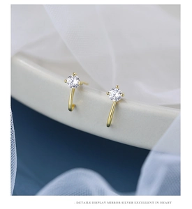 Macro shot of gold-plated S925 silver stud earrings with four-prong cubic zirconia setting