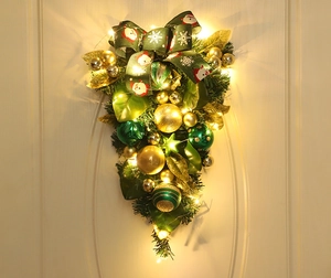 Detail of Christmas teardrop swag with green ribbons, gold ornaments and warm LED lights