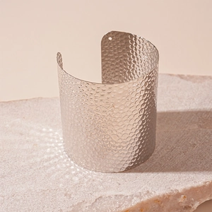 Detail of wide hammered silver cuff bracelet with unique circular hole on stone