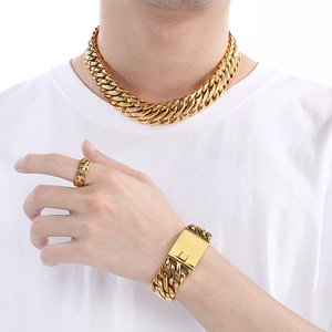 Detailed view of men's gold plated Cuban chain necklace, bracelet and ring set on model